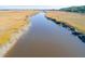 Beautiful aerial view of wide river with marshland on either side, reflecting the clear blue sky at 1602 John Fenwick Ln, Johns Island, SC 29455