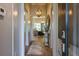 Hallway with hardwood floors leads to a living room with stylish furniture and a modern lighting fixture at 170 Collared Dove Ct, Summerville, SC 29483
