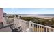 A tranquil balcony with chairs showcases stunning beach views and a serene coastal setting at 19 Grand Pavilion Blvd, Isle of Palms, SC 29451
