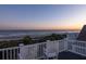 Breathtaking sunset beach view from a deck with rocking chairs at 19 Grand Pavilion Blvd, Isle of Palms, SC 29451