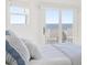 Bedroom with large windows, ocean view, and white and blue bedding at 19 Grand Pavilion Blvd, Isle of Palms, SC 29451