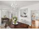 Elegant dining room with hardwood floors, stylish chandelier, and views to a modern white kitchen at 19 Grand Pavilion Blvd, Isle of Palms, SC 29451