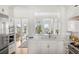 Bright kitchen featuring marble countertops, stainless steel appliances, and an open view to living area at 19 Grand Pavilion Blvd, Isle of Palms, SC 29451
