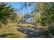 Backyard featuring lush green lawn, mature trees, outdoor chairs, and a view of the home at 2101 Guerins Bridge Rd, Wando, SC 29492