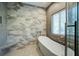 Bright bathroom featuring a soaking tub with a glass enclosure and decorative tile creating a spa-like experience at 2101 Guerins Bridge Rd, Wando, SC 29492