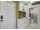 Functional laundry area with modern sink and storage, adjacent to a door and a well-lit bathroom at 2101 Guerins Bridge Rd, Wando, SC 29492