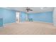 Large light blue bedroom with carpet, trim, ceiling fan, and an open doorway to an additional room at 2101 Heavens Way, Summerville, SC 29483