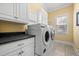 Bright laundry room with large capacity washer and dryer, storage cabinets, and granite countertop at 2101 Heavens Way, Summerville, SC 29483