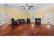 Open living room with a fireplace, ceiling fan, hardwood floors, and access to backyard at 2101 Heavens Way, Summerville, SC 29483