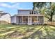 Backyard view showing a screened porch, a well-maintained lawn, and mature trees providing shade at 2210 Norwood Oaks Dr, Mount Pleasant, SC 29466