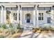 Inviting front entrance with white columns, blue accents, and neat landscaping and a dark blue door at 2210 Norwood Oaks Dr, Mount Pleasant, SC 29466