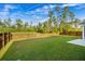 Expansive backyard with a well-manicured lawn, bordered by a classic wooden fence and tall trees at 242 Bering Ln, Summerville, SC 29486