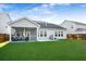 Spacious backyard features a lush lawn, a covered grill, and a screened in porch with comfortable seating at 242 Bering Ln, Summerville, SC 29486