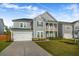 Charming two-story home featuring a covered porch, a two car garage, and a well-manicured lawn at 242 Bering Ln, Summerville, SC 29486