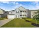 Charming two-story home featuring a landscaped yard, two car garage, and a cozy front porch and balcony at 242 Bering Ln, Summerville, SC 29486