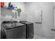 Modern laundry room features a front-load washer and dryer with upper shelf storage at 242 Bering Ln, Summerville, SC 29486