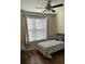 This bedroom features a ceiling fan, a window with blinds, and hardwood floors at 2598 Spivey Ct, North Charleston, SC 29406
