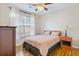 Cozy bedroom features a window, ceiling fan, hardwood floors, and stylish furnishings at 2598 Spivey Ct, North Charleston, SC 29406