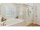 Elegant bathroom featuring a soaking tub, glass-enclosed shower, and white tile at 3000 Flat Rock Ln, Ridgeville, SC 29472