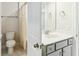 Bathroom featuring a sink with gray cabinets and a toilet and shower behind an open door at 3000 Flat Rock Ln, Ridgeville, SC 29472