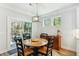 Cozy breakfast nook featuring a round wooden table, chandelier, and view of the private backyard at 3000 Flat Rock Ln, Ridgeville, SC 29472