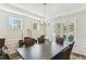 Elegant dining room featuring a large wooden table, decorative chandelier, and two windows with plantation shutters at 3000 Flat Rock Ln, Ridgeville, SC 29472