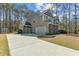Charming two-story home with gray siding, stone accents, long driveway, and attached two-car garage at 3000 Flat Rock Ln, Ridgeville, SC 29472