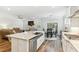 Open concept living space with kitchen island, gas range, and view into the living room and breakfast nook at 3000 Flat Rock Ln, Ridgeville, SC 29472