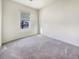 Bright, carpeted bedroom featuring a large window, neutral walls, and a view of the neighborhood at 307 Sedona Dr, Summerville, SC 29486