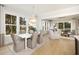 Bright dining area flowing into a living space with hardwood floors and oversized windows at 377 Blowing Fresh Dr, Charleston, SC 29492
