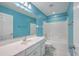 Bright bathroom with blue walls, white tile shower and vanity with a large mirror at 401 Waring St, Summerville, SC 29483