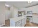 Modern kitchen with white cabinets, stainless steel appliances, an island, and hardwood flooring throughout at 401 Waring St, Summerville, SC 29483