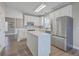 Modern kitchen with white cabinets, stainless steel appliances, an island, and hardwood flooring throughout at 401 Waring St, Summerville, SC 29483