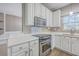 Bright kitchen features white cabinets, quartz countertops, stainless steel appliances, and hardwood floors at 401 Waring St, Summerville, SC 29483