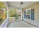 Covered porch with tan walls, white railing, and an area rug on a brick floor at 401 Waring St, Summerville, SC 29483