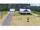 Inviting exterior view of home with a long driveway leading to a detached two-car garage at 407 Sandridge Acres Trl, Holly Hill, SC 29059