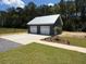 A detached two-car garage with modern white doors and silver roof at 407 Sandridge Acres Trl, Holly Hill, SC 29059