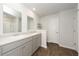 Bathroom featuring double sinks, wood-look flooring, and a shower with a white tile surround at 4678 Palm View Cir, North Charleston, SC 29418