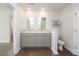 Bathroom featuring double sinks, wood-look flooring, toilet, and an open doorway to a bedroom at 4678 Palm View Cir, North Charleston, SC 29418