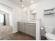 Bathroom featuring double sinks, wood-look flooring, toilet, and an open doorway to a bedroom at 4678 Palm View Cir, North Charleston, SC 29418