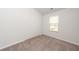 An empty bedroom showcases neutral carpet, white walls, and bright natural light at 4678 Palm View Cir, North Charleston, SC 29418