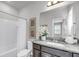 Well lit bathroom featuring granite counters, and a shower tub combo with white tile surround at 524 Amalie Farms Dr, Charleston, SC 29492