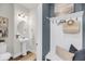 Stylish powder room featuring a sleek pedestal sink, oval mirror, and a lovely beachside decor at 524 Amalie Farms Dr, Charleston, SC 29492
