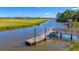 Wooden dock with access to serene water, offering a peaceful waterfront experience at 524 Amalie Farms Dr, Charleston, SC 29492