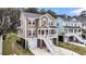 Stunning elevated home featuring a spacious driveway, garage, and tropical landscaping at 524 Amalie Farms Dr, Charleston, SC 29492