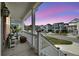 Charming porch with seating area overlooking a peaceful street and neighborhood at dusk at 524 Amalie Farms Dr, Charleston, SC 29492