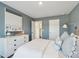 Bedroom featuring grey walls with white dresser, art and bedding, lit by a gold sconce at 5567 Ruby Falls Drive Ln, North Charleston, SC 29420