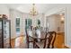 Formal dining room with bright windows, wood table, chandelier and access to an outdoor porch at 601 Foredeck Ln, Edisto Island, SC 29438