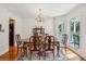 Elegant dining room with wood table, chandelier, china cabinet, large window and wood flooring at 601 Foredeck Ln, Edisto Island, SC 29438