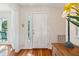 Bright entryway with a white door, wood floors, and a glimpse of outdoor seating at 601 Foredeck Ln, Edisto Island, SC 29438
